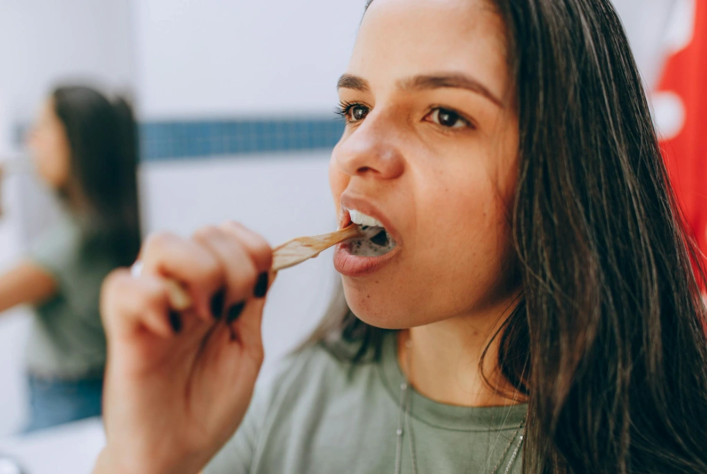 femme se brossant les dents avec une brosse à dents
