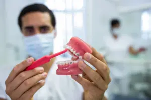 dentist demonstrating oral care full mouth dental implant lema dental clinic